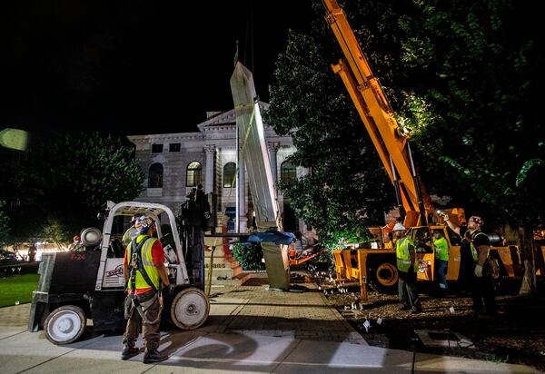 Workers remove a Confederate monument with a crane Thursday, June 18, 2020, in Decatur, Ga. The 30-foot obelisk in Decatur Square, erected by the United Daughters of the Confederacy in 1908, was ordered by a judge to be removed and placed into storage indefinitely. (AP Photo/Ron Harris)