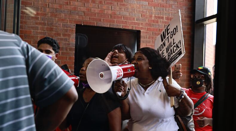 Eve Mayo, center with bullhorn, joined fellow residents of the Forest at Columbia Apartments and activists for a protest at the DeKalb County government complex Thursday. Residents said the complex's management company has told all tenants to be out by Aug. 31.