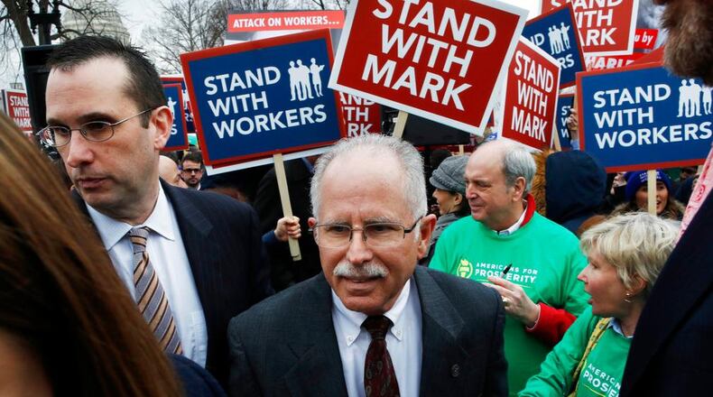 Illinois government employee Mark Janus, center, turns after thanking supporters outside the Supreme Court, Monday, Feb. 26, 2018, in Washington. The Supreme Court takes up a challenge Monday in a case that could deal a painful financial blow to organized labor. The court is considering a challenge to an Illinois law that allows unions representing government employees to collect fees from workers who choose not to join. (AP Photo/Jacquelyn Martin)