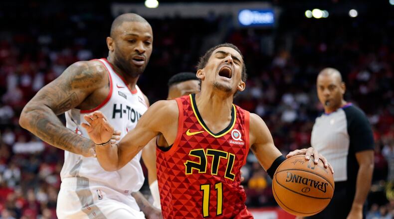 Hawks guard Trae Young (right) drives past Houston Rockets forward PJ Tucker. (AP Photo/Michael Wyke)