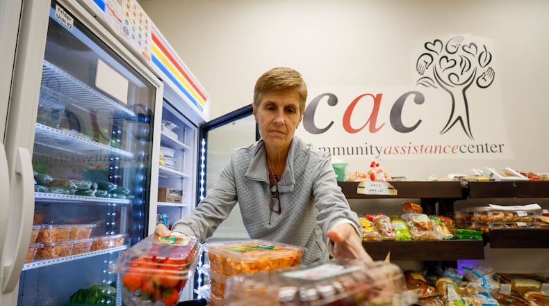 Donna Watkins, a volunteer with the Community Assistance Center in Sandy Springs, brings fruits and vegetables to the fridge at the Mini-Market moments before the outlet opens to the public. The Community Assistance Center's pantry food program serves the Sandy Springs and Dunwoody areas.
Miguel Martinez /miguel.martinezjimenez@ajc.com