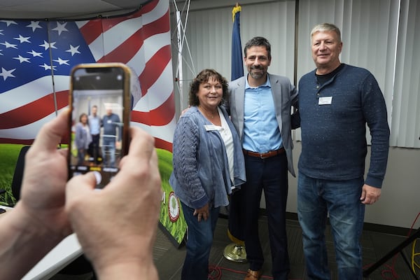 Ryan Kelley, center, poses for a photo after his talk at the Jackson County Republican headquarters, Thursday, April 10, 2025, in Jackson, Mich. (AP Photo/Paul Sancya)