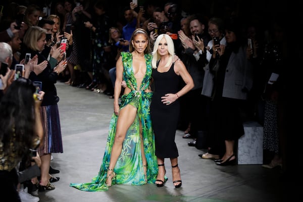 FILE - Actress Jennifer Lopez, left, and designer Donatella Versace accept applause at the conclusion of the Versace Spring-Summer 2020 collection, unveiled during the fashion week, in Milan, Italy, Friday, Sept. 20, 2019. (AP Photo/Luca Bruno, File)