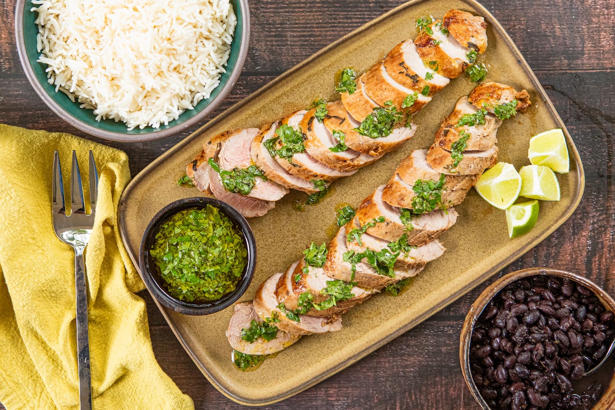 The bright herbs in this quick-cooking mojo-marinated pork tenderloin recipe offer a refreshing alternative to traditional Thanksgiving flavors. (Aaliyah Man for the AJC; food styling by Kate Williams)