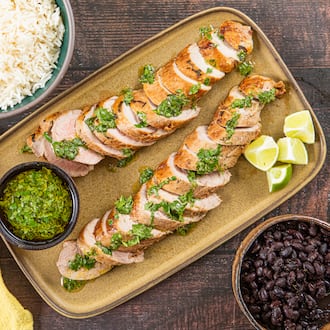 The bright herbs in this quick-cooking mojo-marinated pork tenderloin recipe offer a refreshing alternative to traditional Thanksgiving flavors. (Aaliyah Man for the AJC; food styling by Kate Williams)