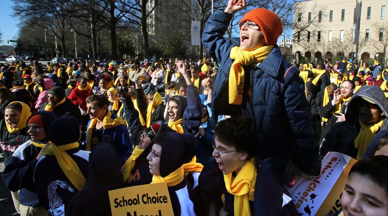 January 31, 2013 - Atlanta, Ga: Yehuda Benschitrit, 14, cheers as the name of his school, Torah Day School of Altanta, is announced as one of many schools that participated in the Georgia School Choice Celebration and Rally at the west entrance to the Georgia State Capitol Thursday morning in Atlanta, Ga., January 31, 2013. Benschitrit, an 8th grade student at Torah Day School of Atlanta, is sitting on the shoulders of fellow 8th grade student, Ben Bogart, 14. More than 2,000 public, private, and home school students met outside the Georgia State Capitol Thursday to call for the expansion of educational opportunities for kids. This is the fourth annual Georgia School Choice Celebration and Rally. JASON GETZ / JGETZ@AJC.COM