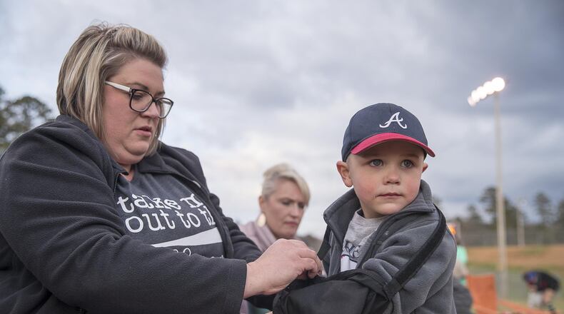 Cami Abernathy readjusts the sling on her son Carter’s arm at Manning Mill Park in Adairsville. Carter recently had surgery to assist with his suspected acute flaccid myelitis, a neurological condition that can cause a polio-like illness. ALYSSA POINTER / ALYSSA.POINTER@AJC.COM
