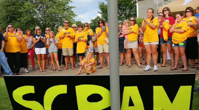About 100 members of SCRAM (Smart Citizens Rally Against Marlow) hold a rally to oust Cherokee School Board member Kelly Marlow in Bridge Mill Subdivision on July 8, 2013, in Canton. Marlow, her political adviser Robert John Trim and secretary of the local Republican Party Barbara Knowles were arrested over the weekend. They have been charged with filing a false police report after they accused the school superintendent of trying to hit them with his car.