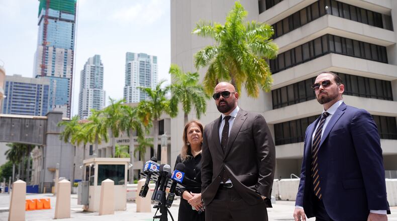 Attorneys Joseph McBride, center, and Jackie Perczek, left, representing Andrew and Tristan Tate as they fight extradition to the United Kingdom, where they are accused of rape and sex trafficking, speak to the media outside the C. Clyde Atkins U.S. Courthouse, Monday, July 27, 2026, in Miami. (AP Photo/Rebecca Blackwell)