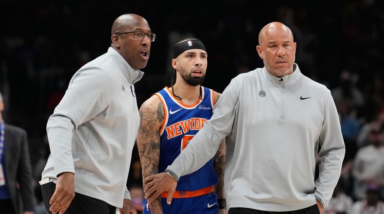 New York Knicks head coach Mike Brown holds back New York Knicks guard Jose Alvarado (5) with another coach during the first half of Game 4 in a first-round NBA playoffs basketball series against the Atlanta Hawks Saturday, April 25, 2026, in Atlanta. (AP Photo/Brynn Anderson)