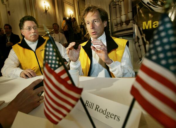 FILE - Four-time Boston Marathon winner, Bill Rodgers, speaks, as Boston Marathon wheelchair winner and pioneer, Bob Hall, listens at left, during a news conference in Boston, April 15, 2005. (AP Photo/Elise Amendola, File)