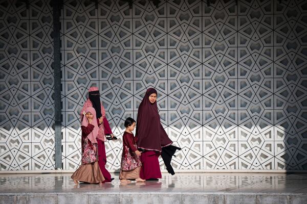 Muslim women walk with children at National Mosque after the Eid al-Fitr prayer marking the end the holy fasting month of Ramadan in Kuala Lumpur, Malaysia, Monday, March 31, 2025. (AP Photo/Vincent Thian)