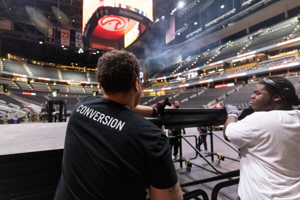 Conversion supervisor Eddie Rivera (left) and technician Kamari Haynes build the main stage for the Maxwell concert at State Farm Arena in October. (Jason Getz/AJC)