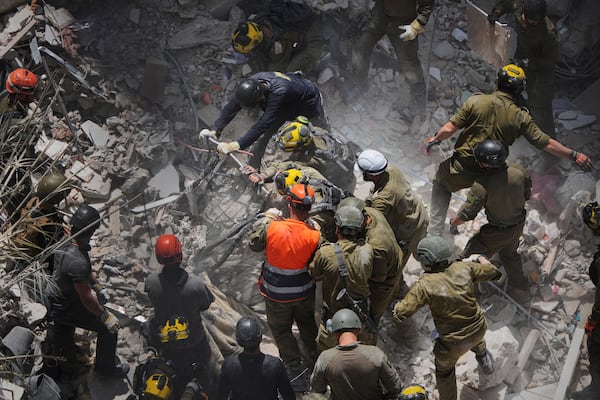 FILE - Israeli soldiers search for survivors amid the rubble of residential buildings destroyed by an Iranian missile strike in Bat Yam, central Israel, June 15, 2025. (AP Photo/Ariel Schalit, File)