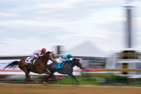 Umberto Rispoli, left, atop Journalism, and Luis Saez, atop Gosger, race to the finish line during the 150th running of the Preakness Stakes horse race Saturday, May 17, 2025, at Pimlico Race Course in Baltimore. (AP Photo/Julio Cortez)