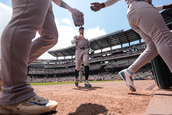 New York Yankees outfielder Aaron Judge, center, walks with his team back to the dugout in the sixth inning of a baseball game against the Atlanta Braves, Sunday, July 20, 2025, in Atlanta. (AP Photo/Mike Stewart)