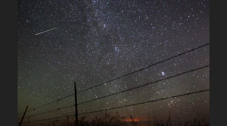 FILE - In this early morning, Aug. 13, 2013 file photo, a meteor streaks past the faint band of the Milky Way galaxy above the Wyoming countryside north of Cheyenne, Wyo., during a Perseids meteor shower. On Thursday night, Aug. 11, 2016 into early Friday morning, the Perseid meteor shower is expected to peak with double the normal number of meteors. Scientists call this an outburst, and they say it could reach up to 200 meteors per hour. (AP Photo/The Wyoming Tribune Eagle, Blaine McCartney)