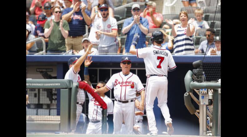 Atlanta Braves shortstop Dansby Swanson is congratulated after scoring during a recent game.
