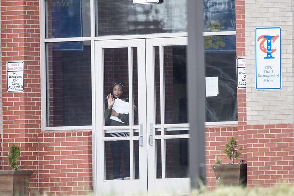 A student waits at the front entrance at Woodland Middle School in East Point, Monday, March 9, 2020. The Fulton County School system has decided to close schools on Tuesday after a teacher tested positive with the coronavirus. 