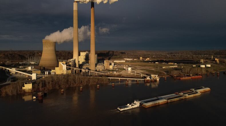 FILE - A barge on the Ohio River moves past the Mountaineer Power Plant, a coal-fired power plant near New Haven, W.Va., March 13, 2026. (AP Photo/Carolyn Kaster, File)