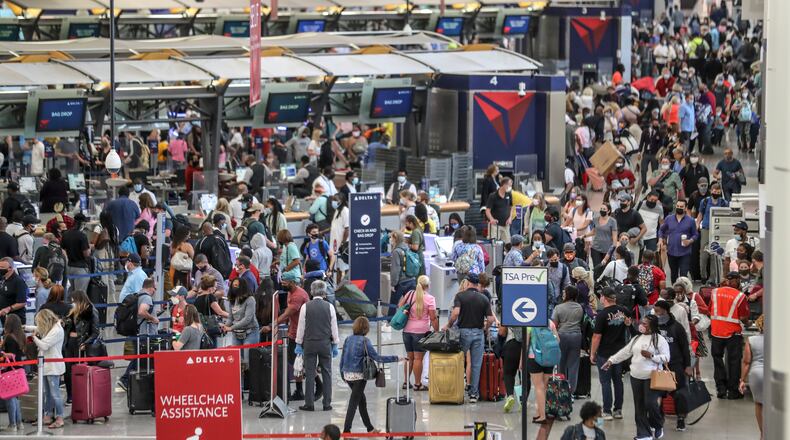 Hartsfield-Jackson International Airport: The Delta ticket counters were swarmed as crowds have returned to Atlanta's Hartsfield-Jackson International Airport for the Memorial Day weekend travel period as seen on Thursday, May 27.  (John Spink / John.Spink@ajc.com)