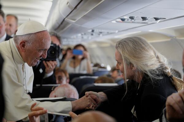 Pope Francis shakes hands with Associated Press correspondent Nicole Winfield aboard his plane bound for Fatima, Portugal, on May 12, 2017. (AP Photo/Alessandra Tarantino)