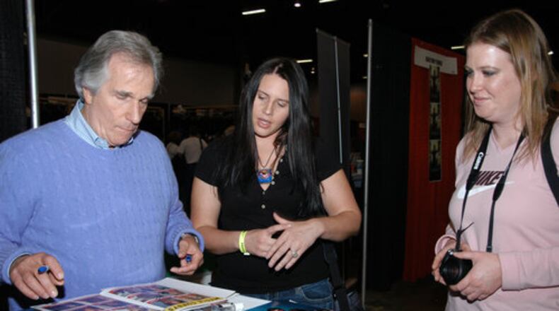 Television legend Henry Winkler (L) autographs an event booklet for Ange Alex (C) and April Bumps (R) at the Wizard World Atlanta Comic Con at Cobb Galleria Centre on Saturday, Dec. 5, 2010.