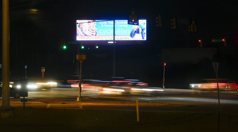 An LED double billboard at the intersection of South Cobb Drive and East-West Connector, which is causing controversy, is shown with blurred lights resulting from slow camera shutter speed capturing traffic streaming by, on Sun., Feb.9, 2020, in Smyrna, Ga. (John Amis)