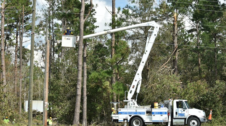 Electric crews work to restore power in Bainbridge, where pecan farmers have been hit hard. AJC photo: Hyosub Shin