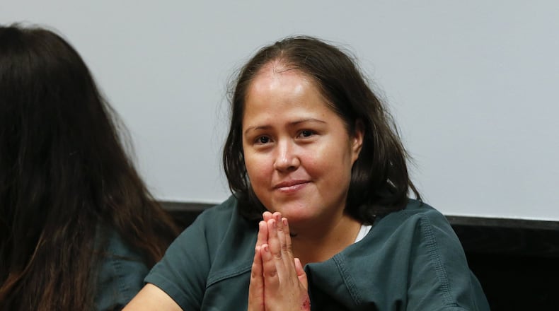 Isabel Martinez gestures towards news cameras during her first court appearance Friday, July 7, 2017, in Lawrenceville , Ga. Martinez is charged with killing four of her children and their father. (AP Photo/John Bazemore)