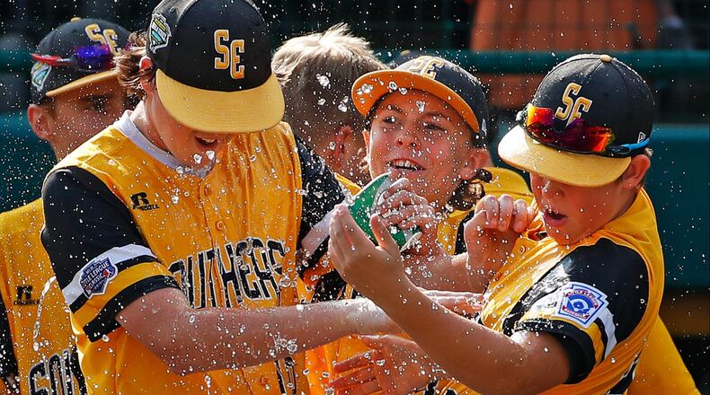 Peachtree City’s Jansen Kenty (lef), and James Hopper (right) get a shower from Will Clem after getting the final out of a 4-3 complete-game win over Grosse Pointe Woods, Mich., in an elimination baseball game Wednesday, Aug. 22, 2018, at the Little League World Series tournament in South Williamsport, Pa.