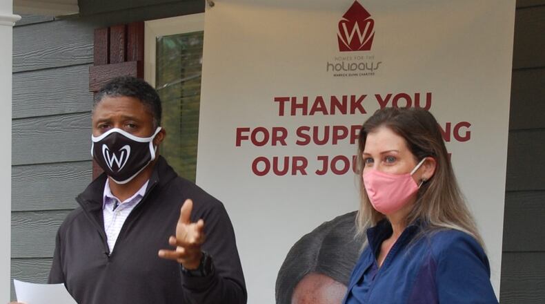 Former NFL star and Atlanta Falcon Warrick Dunn surprised a new Habitat homeowner in Austell when he recently gave her $5,000 for down-payment assistance from his Warrick Dunn Charities. This single mother also received $10,000 worth of furnishings from Aaron's, Inc. (Courtesy of Habitat for Humanity of Northwest Metro Atlanta)