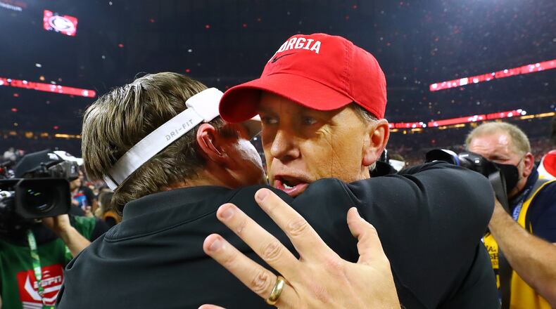 Georgia coach Kirby Smart (left) hugs offensive coordinator Todd Monken after beating Alabama for the national title in 2022. AJC file photo by Curtis Compton / Curtis.Compton@ajc.com”`
