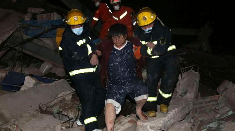 Rescuers help a man from the rubble of a collapsed hotel building in Quanzhou city in southeast China's Fujian province Saturday, March 7, 2020. T