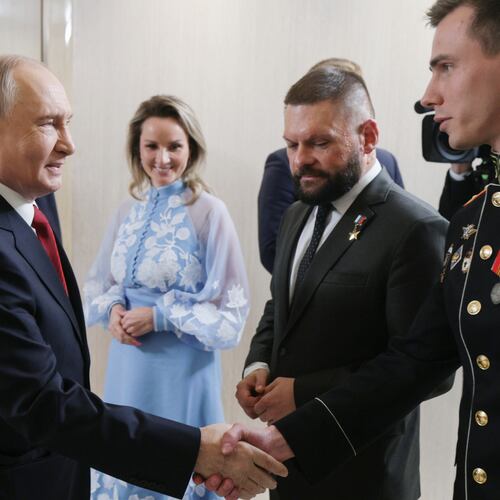 FILE - Russian President Vladimir Putin, left, greets Vladislav Golovin, right, during a meeting with the leaders of the United Russia political party as Presidential Commissioner for Children's Rights Maria Lvova-Belova, center, and military correspondent Yevgeny Poddubny, second right, in Moscow on Saturday, Sept. 5, 2026. (Gavriil Grigorov/Sputnik, Kremlin Pool Photo via AP, File)