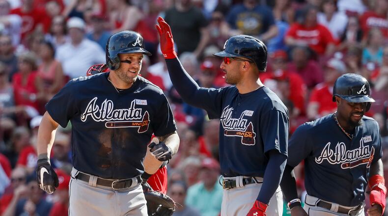 Braves first baseman Matt Adams, left, celebrates with Nick Markakis and Brandon Phillips after hitting a grand slam on Saturday. (AP Photo/John Minchillo)