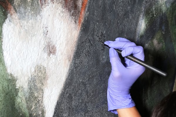 Standing on a 32-foot-tall scaffold, conservation technician Celeste Parrendo works on repairing a mural by Maxo Vanka inside St. Nicholas Croatian Catholic Church in Millvale, Pa., Monday, May 19, 2025. (AP Photo/Gene J. Puskar)