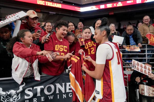 FILE - Southern California guard JuJu Watkins signs autographs for fans after an NCAA college basketball game against Minnesota in Los Angeles, Thursday, Jan. 30, 2025. (AP Photo/Eric Thayer, File)