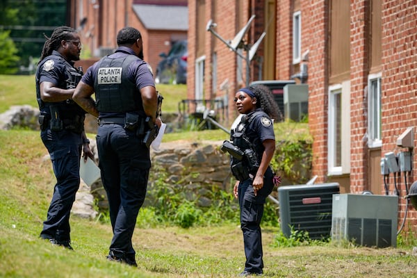 About an hour after the shooting, officers were still searching the area and placing evidence markers near the back of the apartment complex. A police K-9 was also at the scene. (Ben Hendren for the AJC)