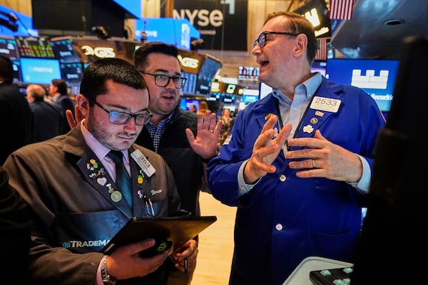 Traders Drew Cohen, left, and Joseph Lawler, center, work with specialist Patrick King on the floor of the New York Stock Exchange, Tuesday, June 10, 2025. (AP Photo/Richard Drew)