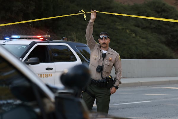 A sheriffs deputy monitors a street closure near the site of an explosion at the LA County Sheriff's Special Operations Bureau on Friday, July 18, 2025, in Los Angeles. (AP Photo/Etienne Laurent)