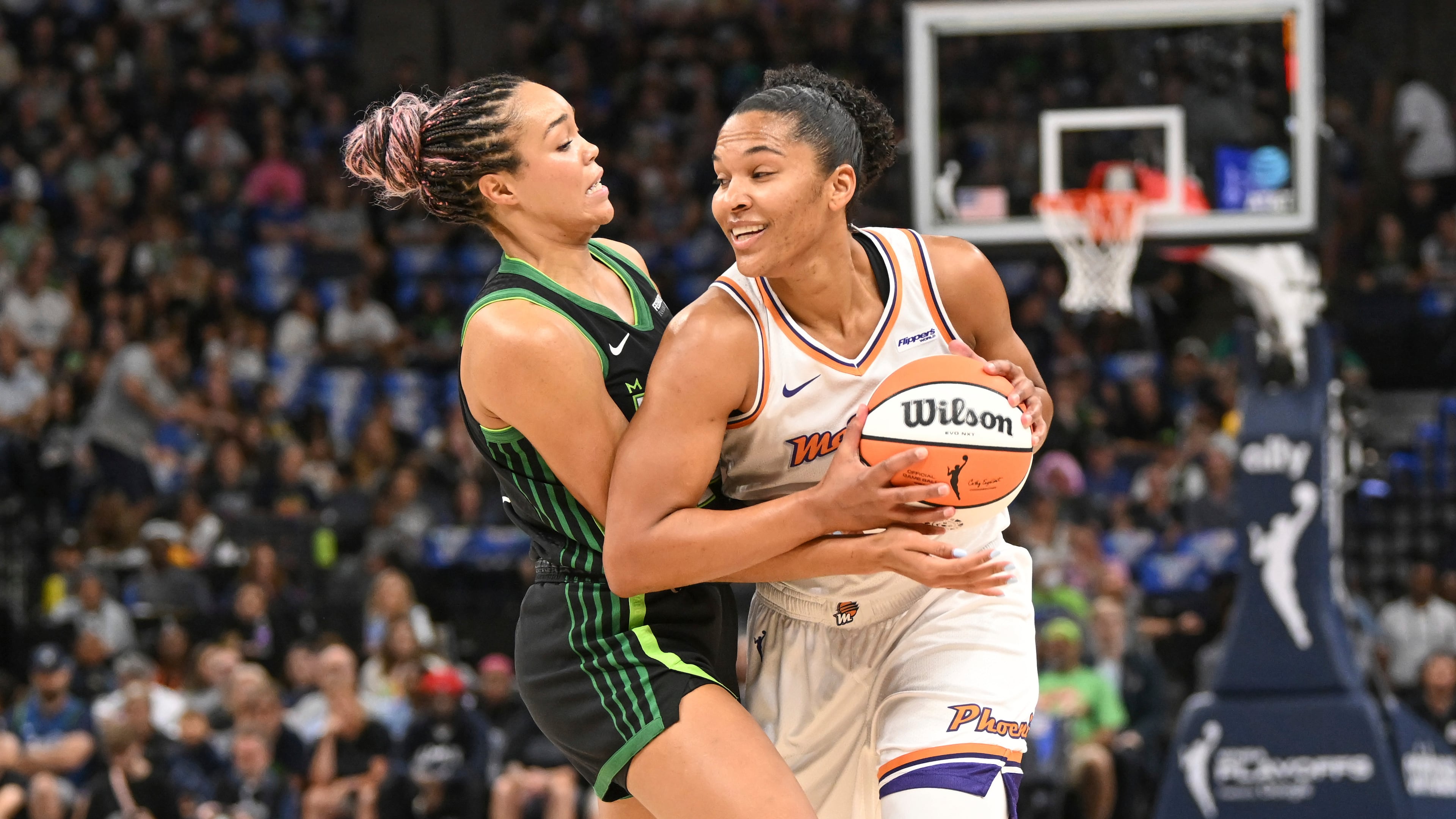 Phoenix Mercury forward Alyssa Thomas, right, tries to drive past Minnesota Lynx forward Napheesa Collier, left, during the first half of Game 1 of a WNBA basketball playoff semifinals series Sunday, Sept. 21, 2025, in Minneapolis. (AP Photo/Craig Lassig)