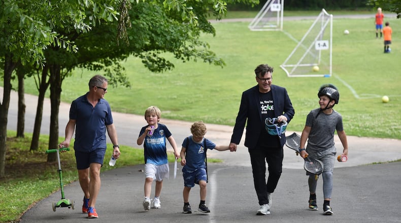 This will be the first Father’s Day that they’re officially a family: Matthew Simon and Keith Schumann walk with their sons Hunter, 6, Owen, 4, and Jackson, 10, after soccer practice. HYOSUB SHIN / HSHIN@AJC.COM