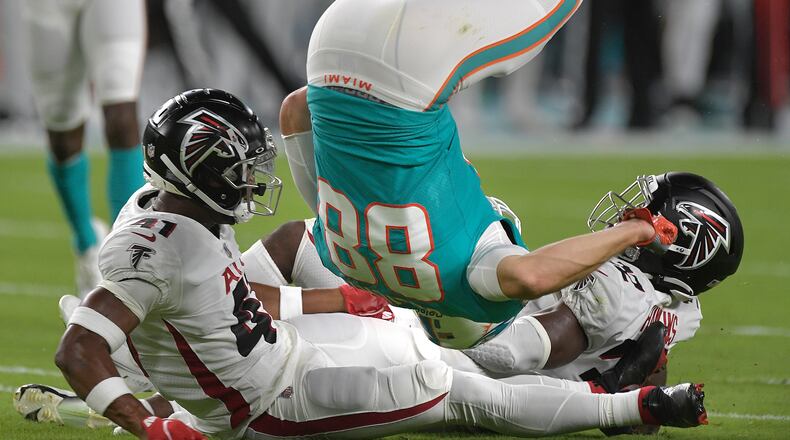 Miami Dolphins tight end Mike Gesicki (88) flips over two Atlanta Falcons defenders after catching a pass in the first half in a preseason game at Hard Rock Stadium in Miami Gardens, Florida, on Saturday, Aug. 21, 2021. The Dolphins won, 37-17. (Michael Laughlin/South Florida Sun Sentinel/TNS)