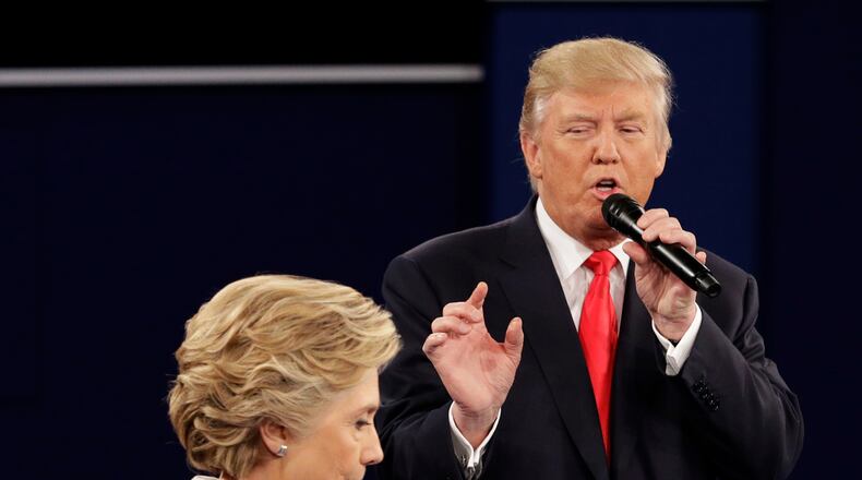 FILE - In this Sunday, Oct. 9, 2016 file photo, Democratic presidential nominee Hillary Clinton walks past Republican presidential nominee Donald Trump during the second presidential debate at Washington University in St. Louis. (AP Photo/John Locher)