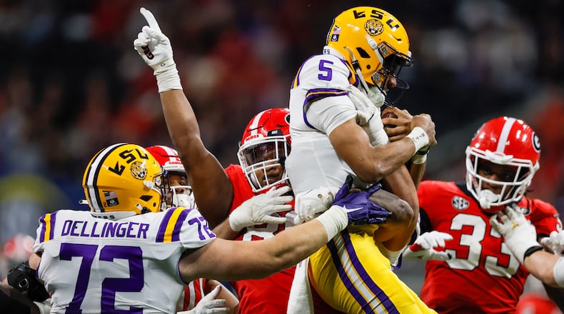 Georgia Bulldogs defensive lineman Jalen Carter (88) stops and lifts up LSU Tigers quarterback Jayden Daniels (5) during the second half of the SEC Championship Game at Mercedes-Benz Stadium in Atlanta on Saturday, Dec. 3, 2022. (Jason Getz / Jason.Getz@ajc.com)