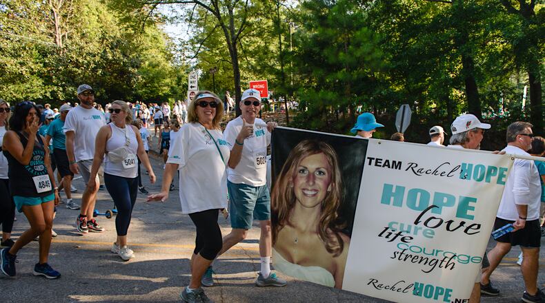 Donna and Larry Aber carry a banner with the image and message of their daughter, Rachel, during the annual Teal Trot fundraiser.