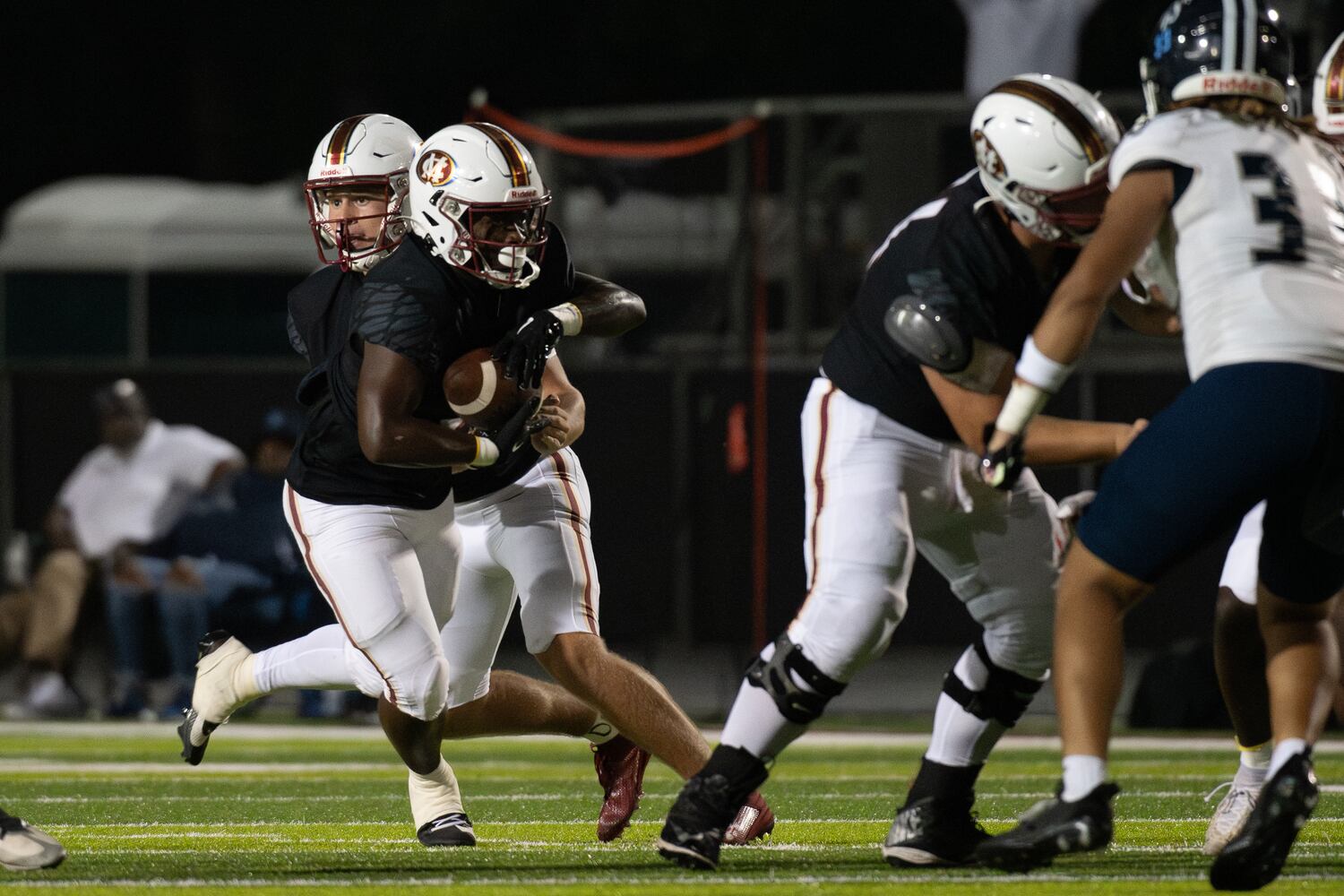 Trey Walker, for Mill Creek, passes the ball off for a run during the Cedar Grove at Mill Creek HS football game, September 15, 2023. (Jamie Spaar for the Atlanta Jounal Constitution)