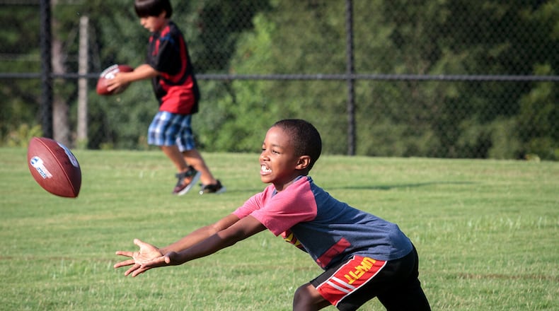 Levi Goodson goes after a football while warming up for the Punt Pass and Kick competition at Rhodes Jordan Park in Lawrenceville, GA Saturday, July 30, 2016. STEVE SCHAEFER / SPECIAL TO THE AJC