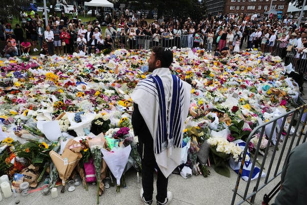 Mourners gathered by the Bondi Pavilion in Australia on Tuesday after at least 15 people were fatally gunned down during a Hanukkah celebration on Dec. 14. (Mark Baker/AP)